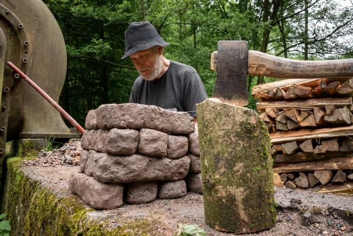 Stará huť u Adamova, květen 2024, Tore Haug-Warberg připravuje stavební materiál na zmenšenou pec dle Ole Evenstada (čti Ture a Ule)