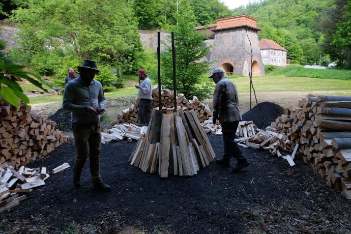 Skládání dřeva do kužele kolem krále